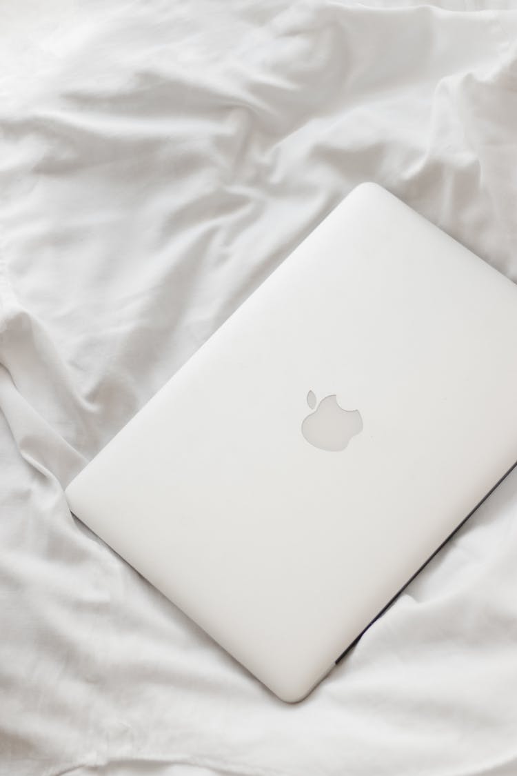 Closed Laptop Laying On White Sheets