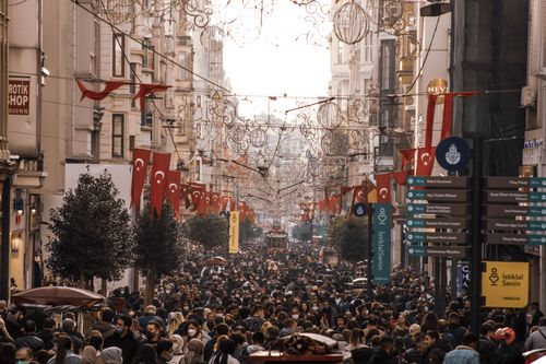 Free Bustling street scene of Istiklal Avenue, Istanbul, with Turkish flags and people wearing masks. Stock Photo
