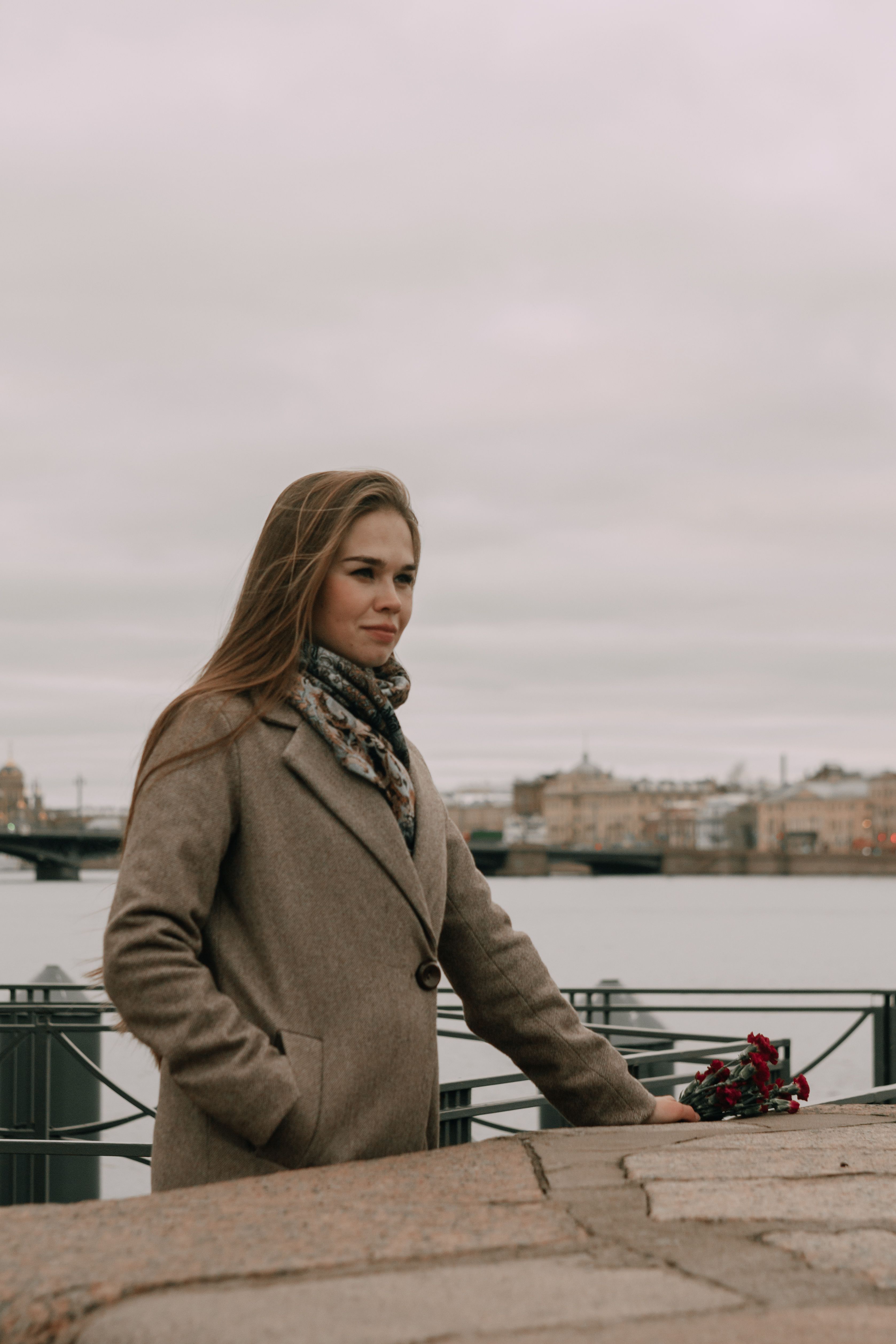 Woman in Brown Coat Standing Near Body of Water · Free Stock Photo