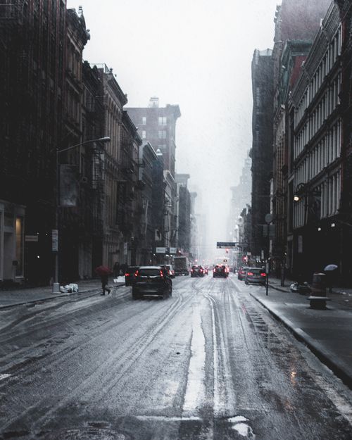 Free A rainy city street with cars and a foggy atmosphere, capturing urban life. Stock Photo