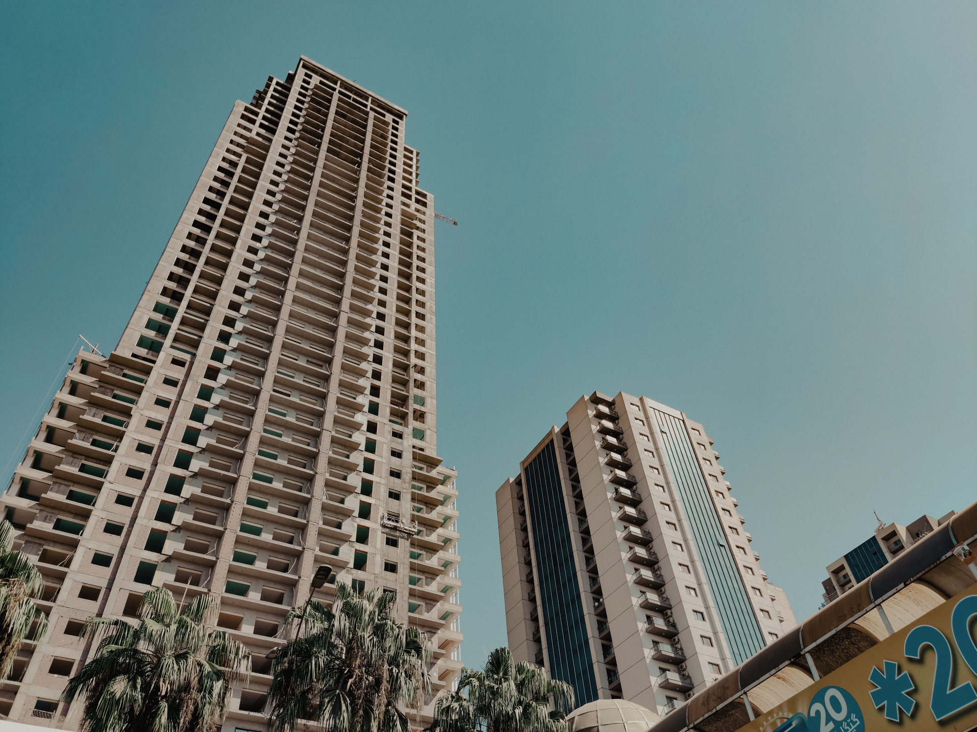Low-angle view of skyscrapers in Iraq with a clear blue sky, showcasing modern architecture.
