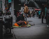 这幅凄美的街景，描绘了繁华都市中一位无家可归者与他的狗