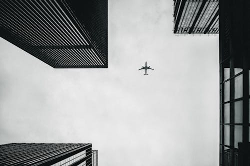 Free Low Angle Photography of Airplane And Buildings Stock Photo