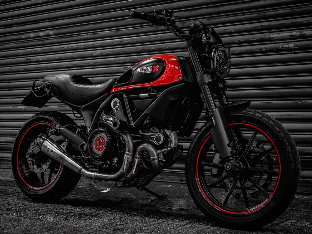 A Red and Black Motorcycle Parked Beside a Gray Roll Up Door