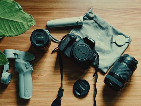 Top-down view of various photography equipment arranged on a wooden surface, showcasing a professional camera setup.