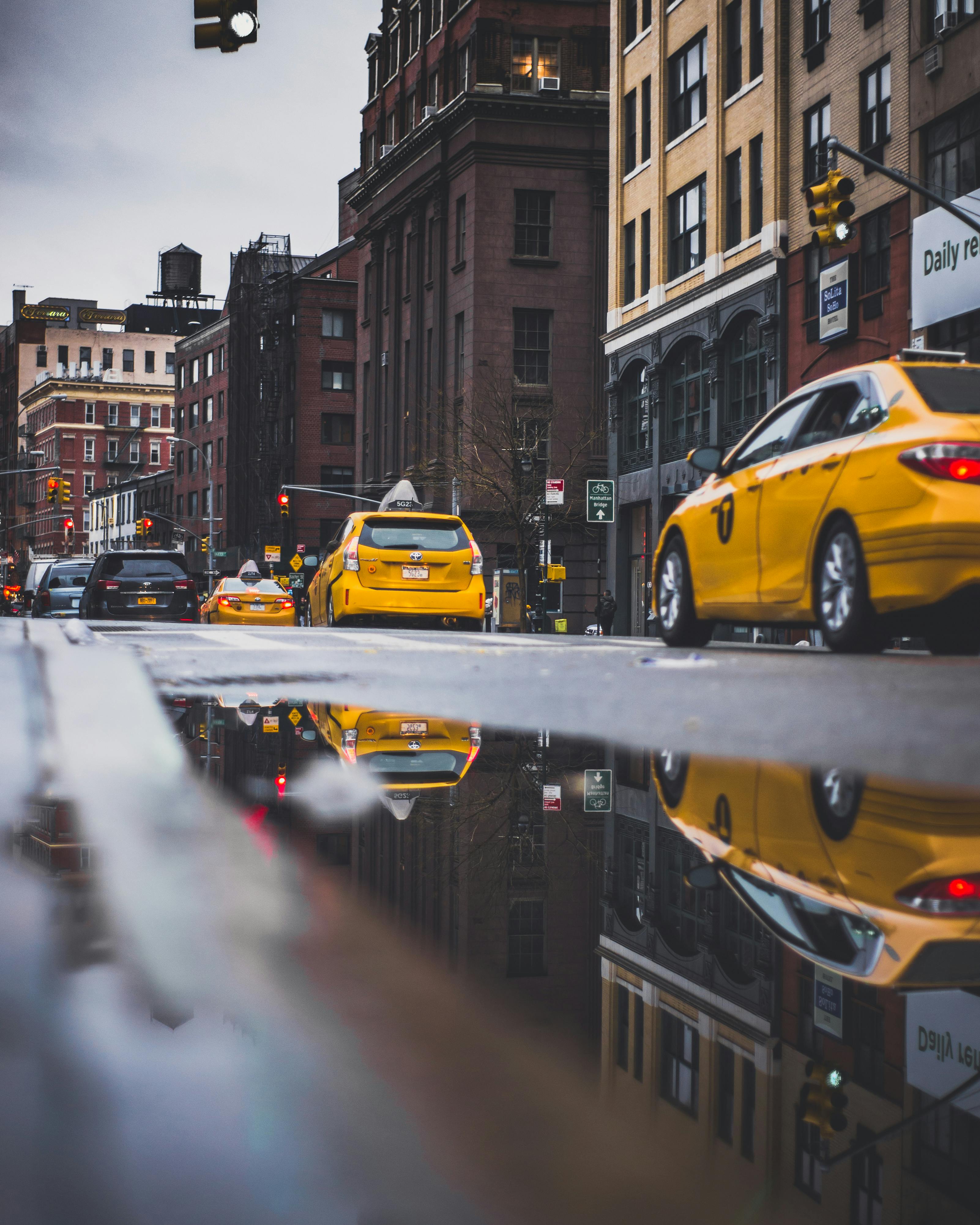 充满活力的城市街道上，黄色的出租车穿梭其间，水坑映照着历史建筑