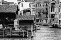 Grayscale Photo of Boat on River Near Houses