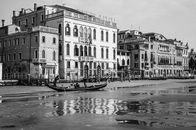 Grayscale Photo of People Riding on Boat on River Near Buildings