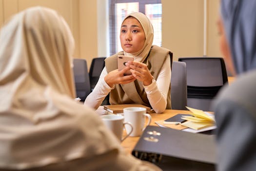 Young Muslim women in an office meeting discussing business strategies, focused and engaged.