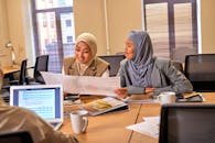 Muslim Female Colleagues Talking About Task in Office Room