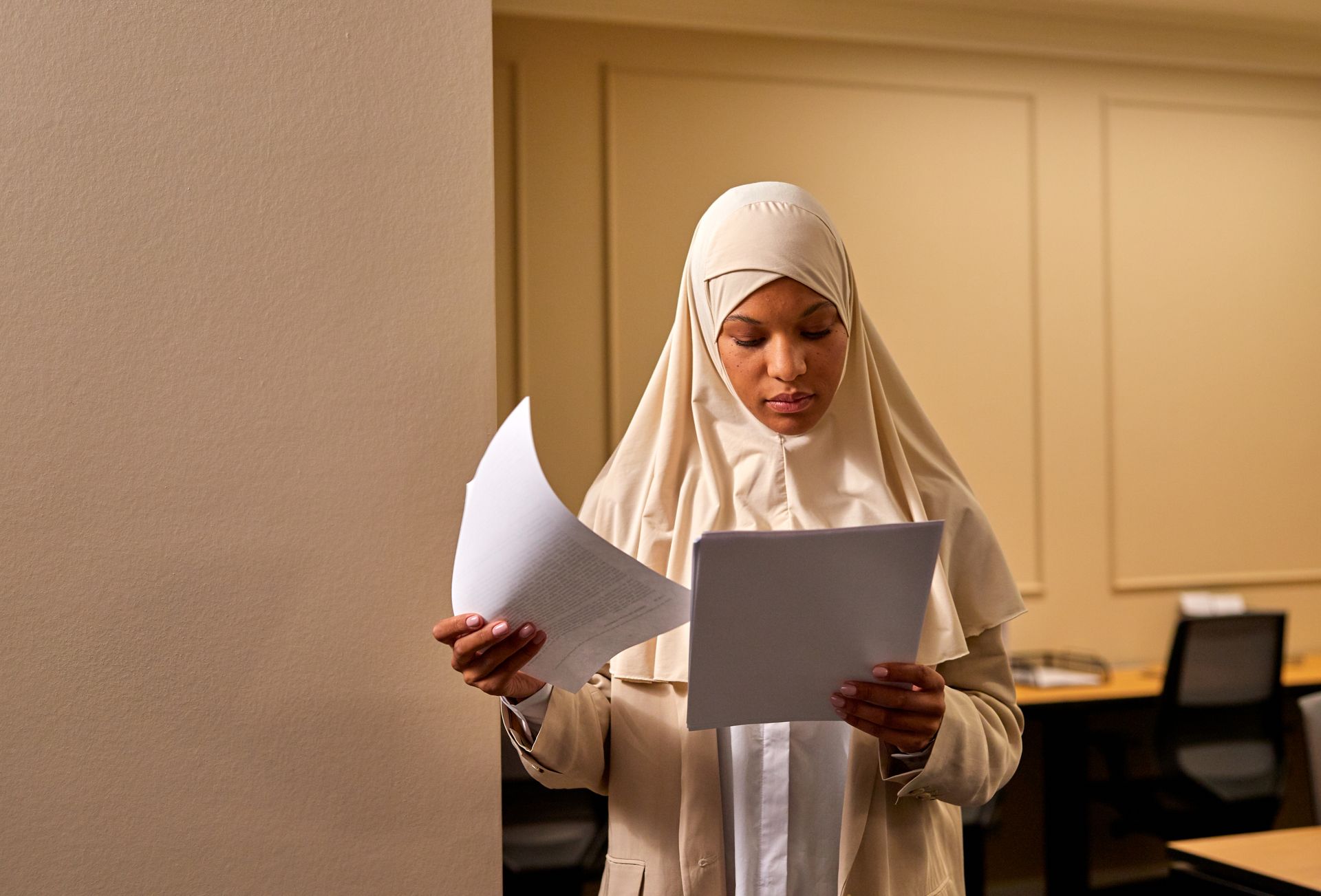 Female Muslim Reviewing Documents in Hands