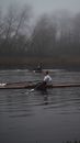 People Rowing on a Boat in the Lake Covered with Fog