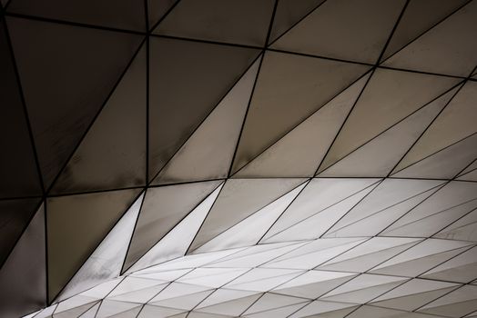 Abstract view of a geometric architectural structure with triangular patterns and smooth lines.