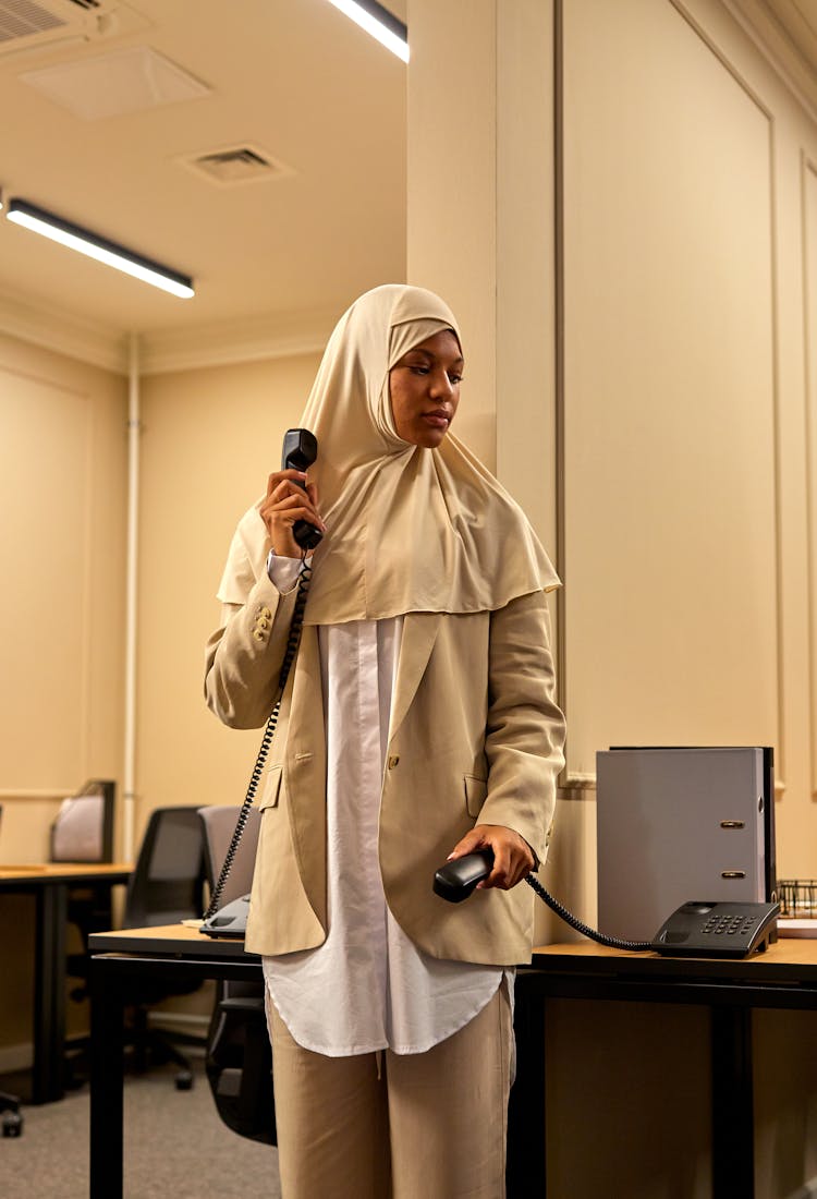 Woman In Hijab In Office Holding Phones