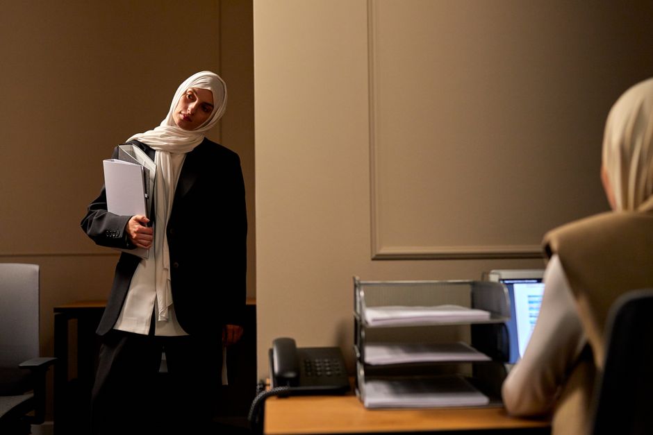 Dos mujeres con hijab colaborando en un entorno profesional de oficina.