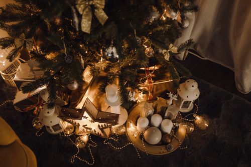 Free Warm Christmas scene with decorated tree, candles, and festive gifts under soft lighting. Stock Photo