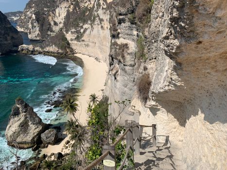 A breathtaking view of Atuh Beach in Bali, Indonesia, featuring a rugged coastline and vibrant blue waters.