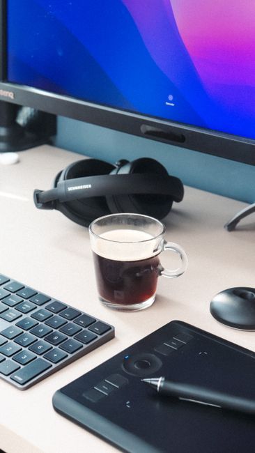 Fotomural Configuración de oficina acogedora con café, auriculares y dispositivos tecnológicos.