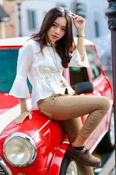 在城市环境中，一位时尚的女人摆出经典的红色迷你库珀