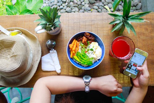 Free Woman Holding Iphone While Eating Stock Photo