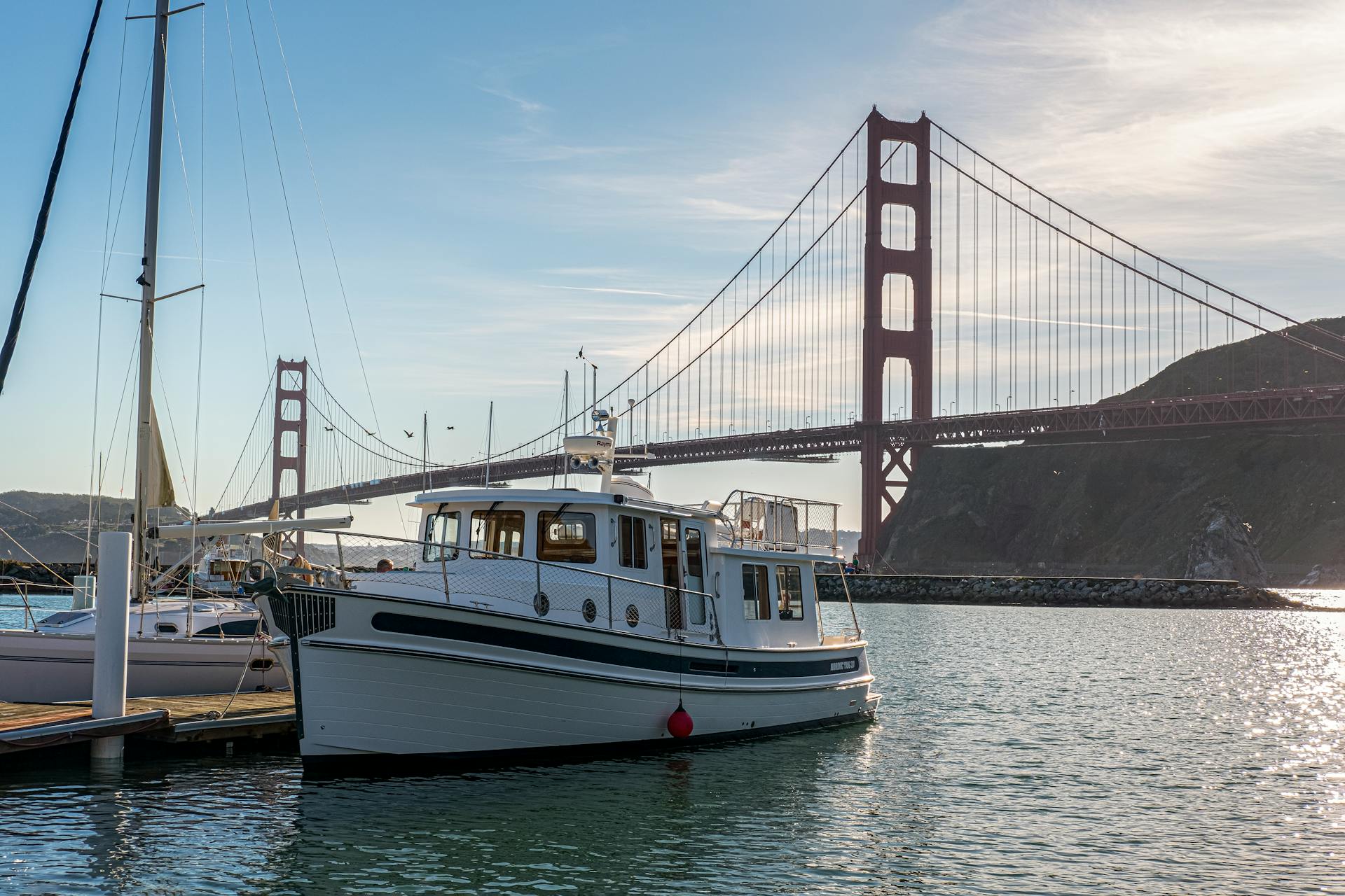 Captivating view of Golden Gate Bridge and docked boats in San Francisco at sunset.