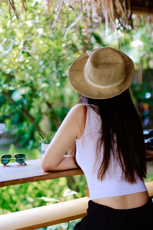 Free Woman Wearing White Tank Top and Black Pants With Brown Sun Hat Stock Photo