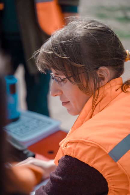 A dedicated volunteer coordinates a search effort outdoors, wearing an orange safety vest.