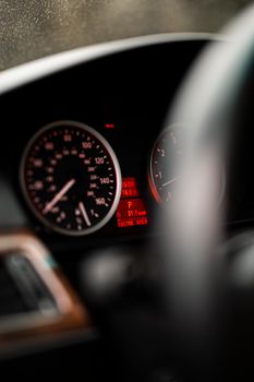 Selective focus on car speedometer in a vehicle dashboard interior.