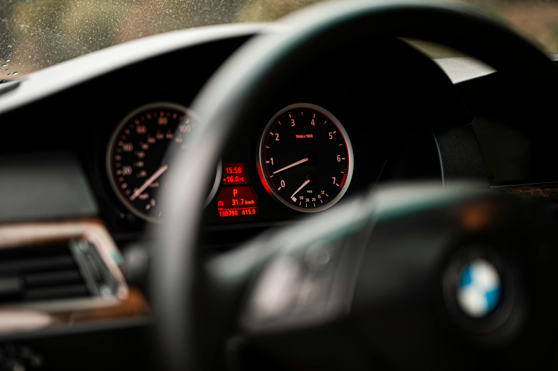 Detailed view of a car dashboard displaying speedometer and RPM gauges in focus.