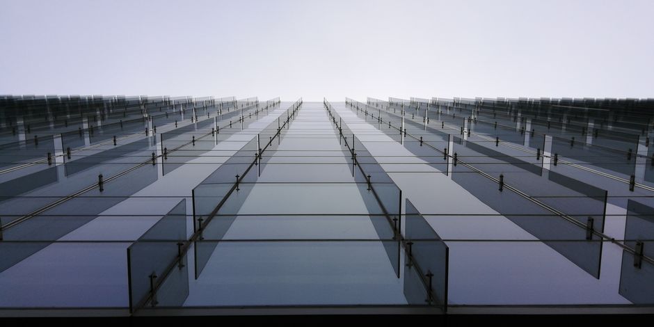 Low angle view of a modern glass facade skyscraper in Pune, India with clear sky. Low angle view of a modern glass facade skyscraper in Pune, India with clear sky.