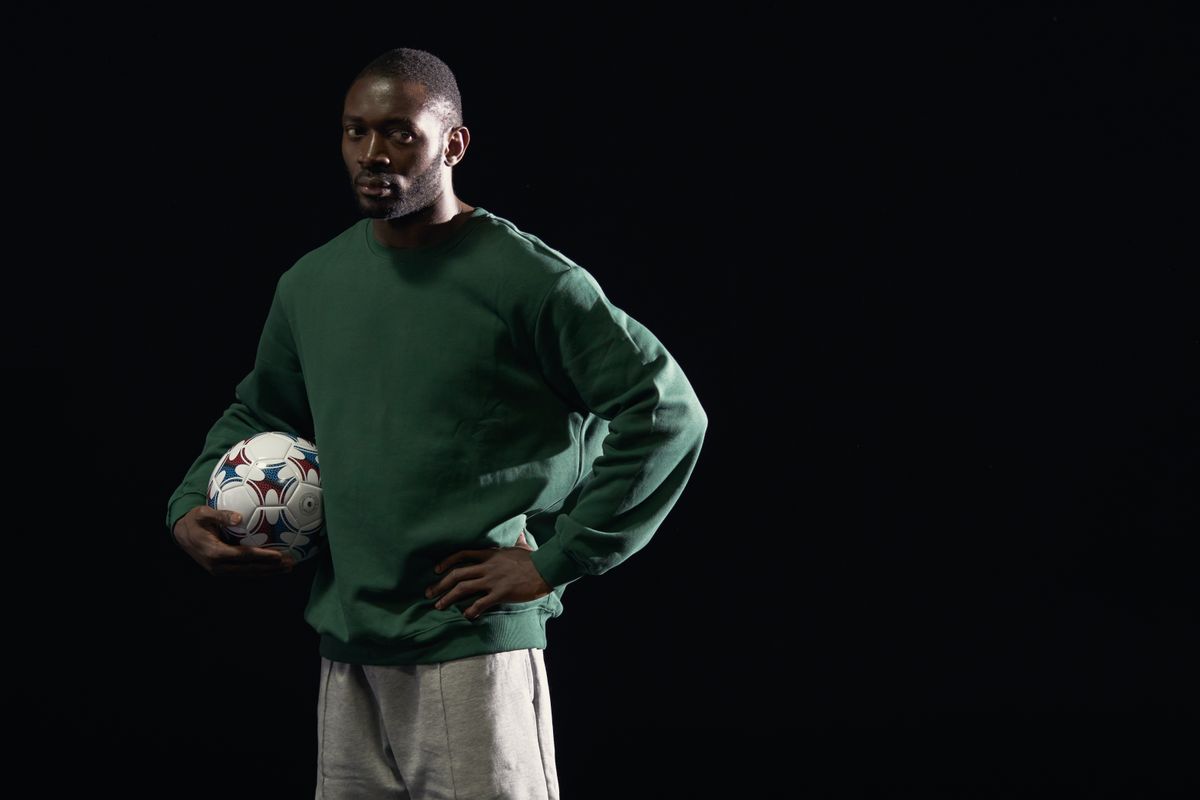 Athlete holding a football in studio light