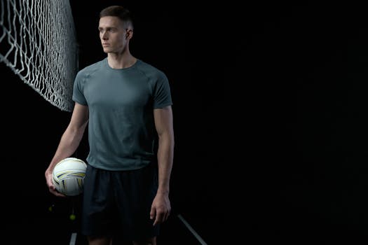 Focused volleyball player holding ball in a studio setting.