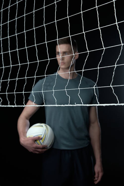 Person Holding a Ball Behind a Net