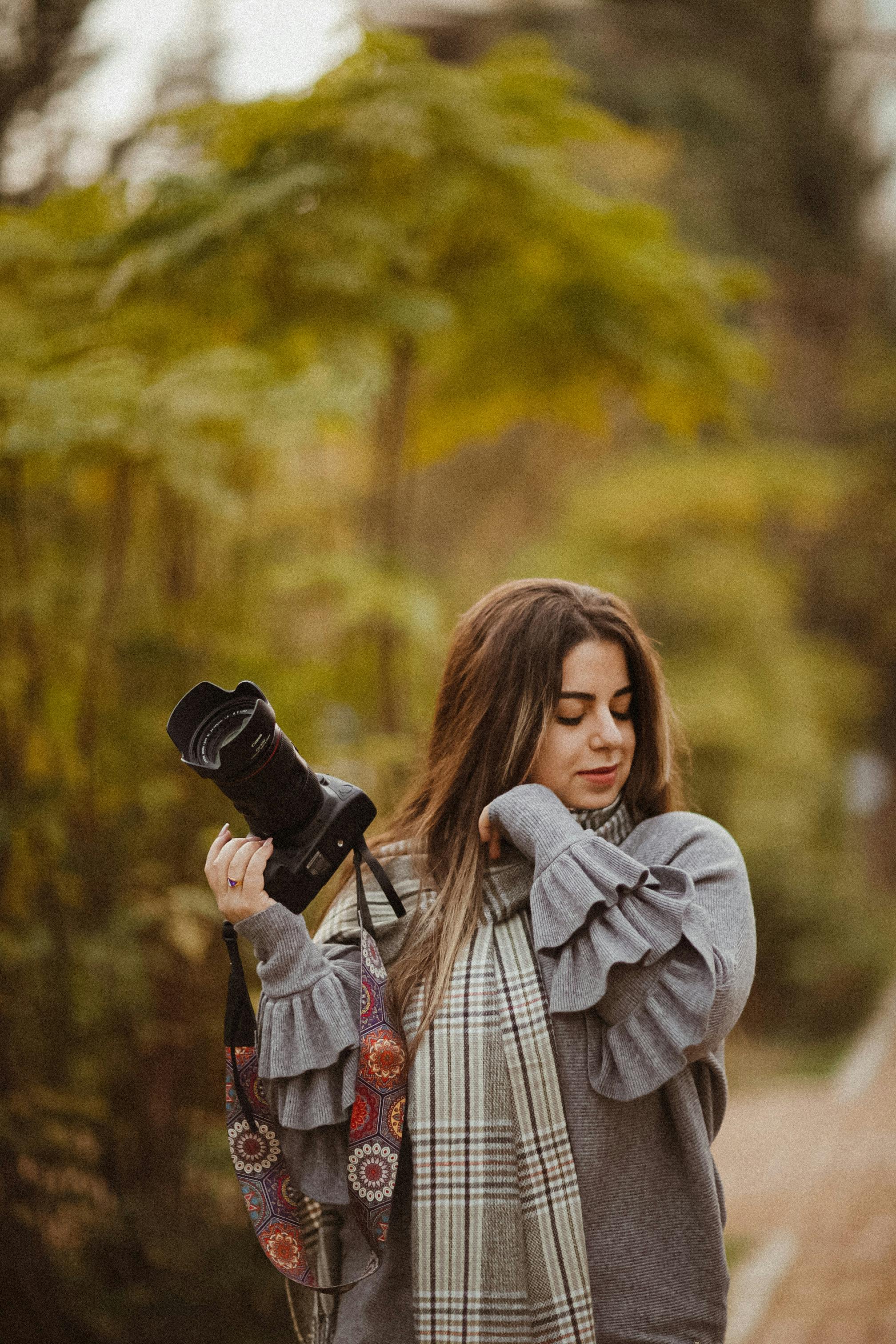 woman in gray long sleeve shirt holding black dslr camera