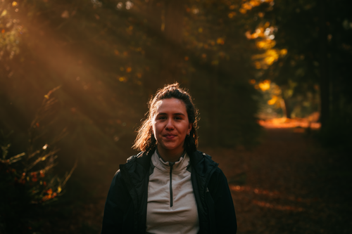 Free A woman smiling on a sunlit forest trail in autumn, Boxtel, Netherlands. Stock Photo