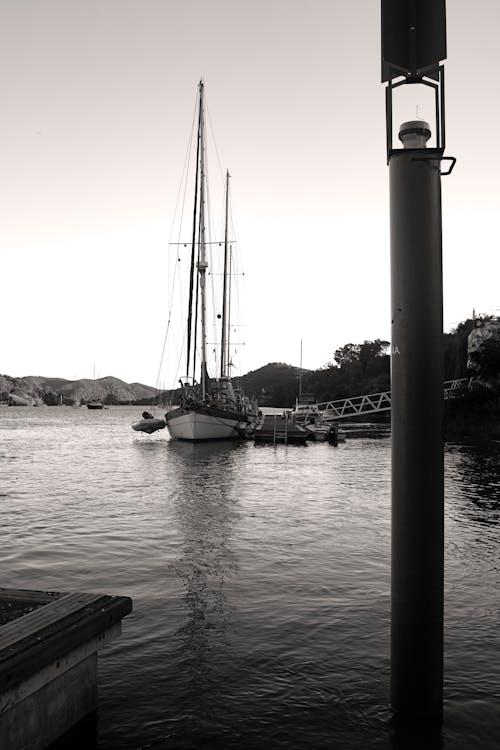 Grayscale Photo of White Boat on Dock