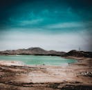 在广阔的天空下，碧绿的沙漠湖泊与壮丽的海水凸显了干旱景观的独特之美