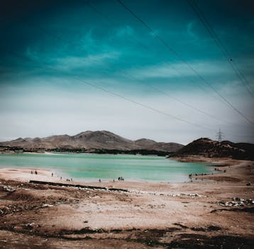 在广阔的天空下，碧绿的沙漠湖泊与壮丽的海水凸显了干旱景观的独特之美