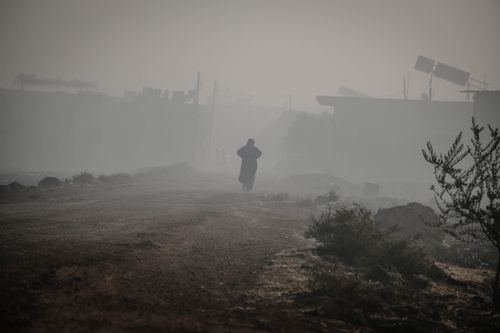 Free A person walks down a foggy rural road in Idlib, Syria, creating an eerie atmosphere. Stock Photo