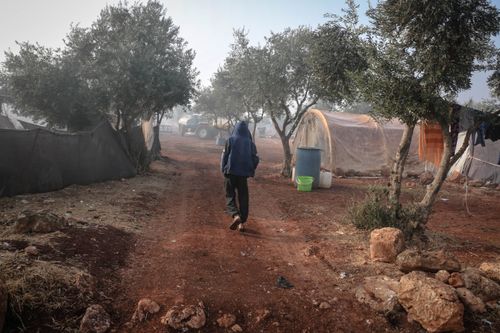 Free A person walks through a refugee camp in Idlib, Syria, showcasing daily life. Stock Photo