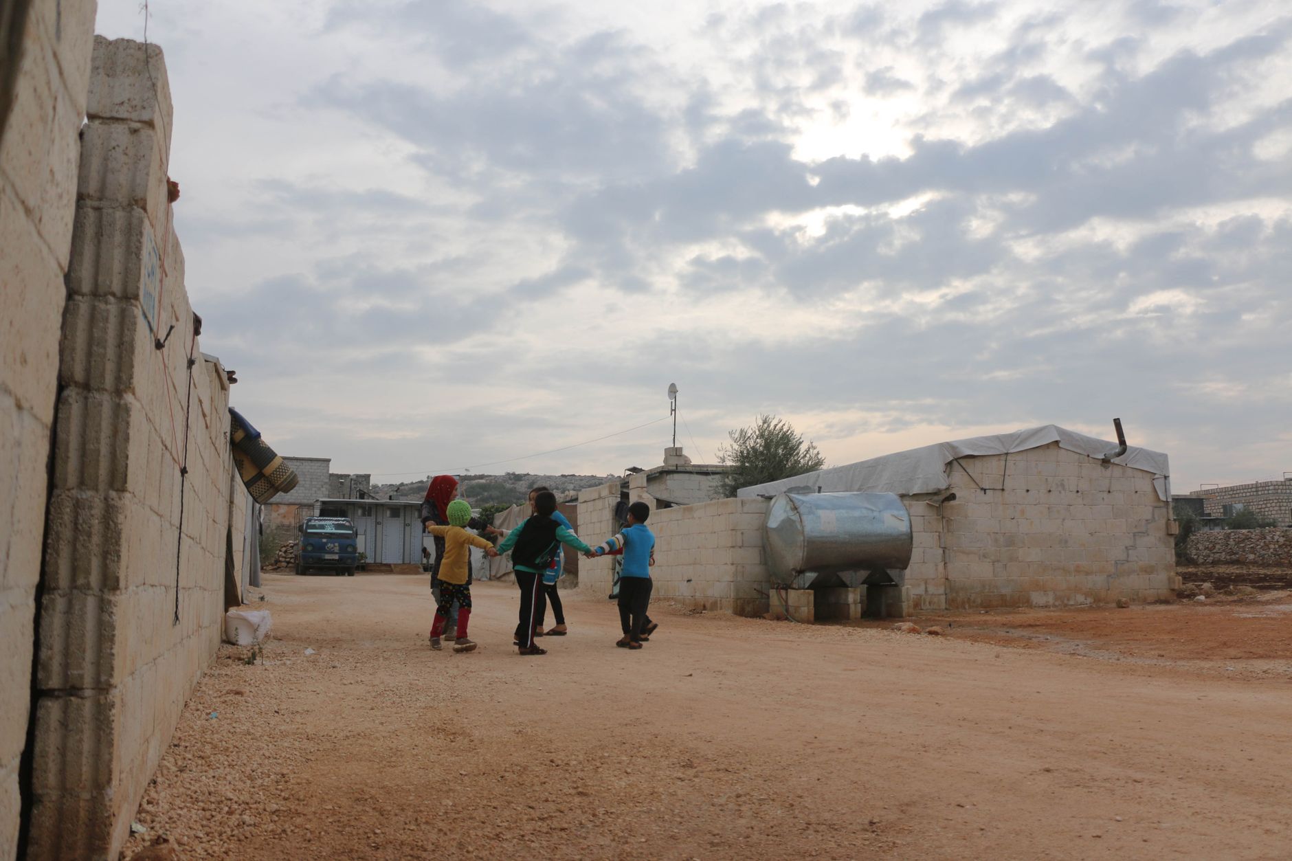 A group of children enjoying a day outside on a dirt road in Idlib, Syria.