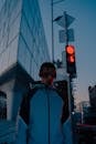 Man in Blue and Black Zip Up Jacket Standing Near White Building