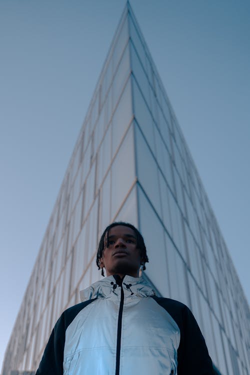 Free Man Wearing a Jacket Standing Near a Building Stock Photo