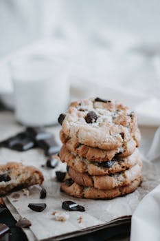 A stack of homemade chocolate chip cookies on a rustic napkin, perfect for a snack.