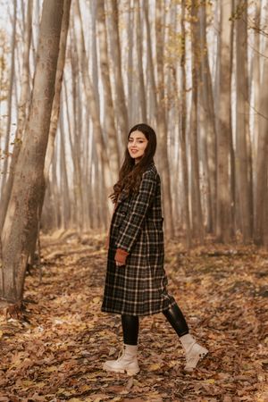 Woman in plaid thrift coat with leggings and boots