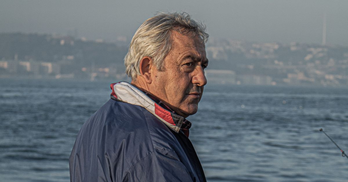 Rüyada Erken Emeklilik Görmek - Rüya Tabiri ve Anlamı - Senior man enjoys fishing by the sea at sunrise, capturing serenity and leisure.