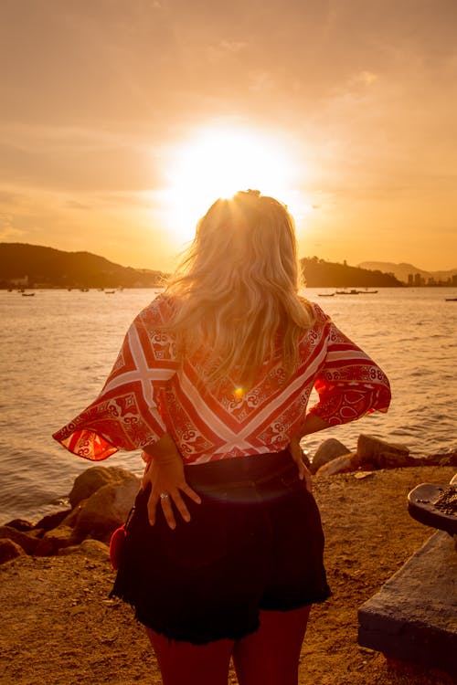 Free Woman in Red Blouse Standing on Lakeside Stock Photo