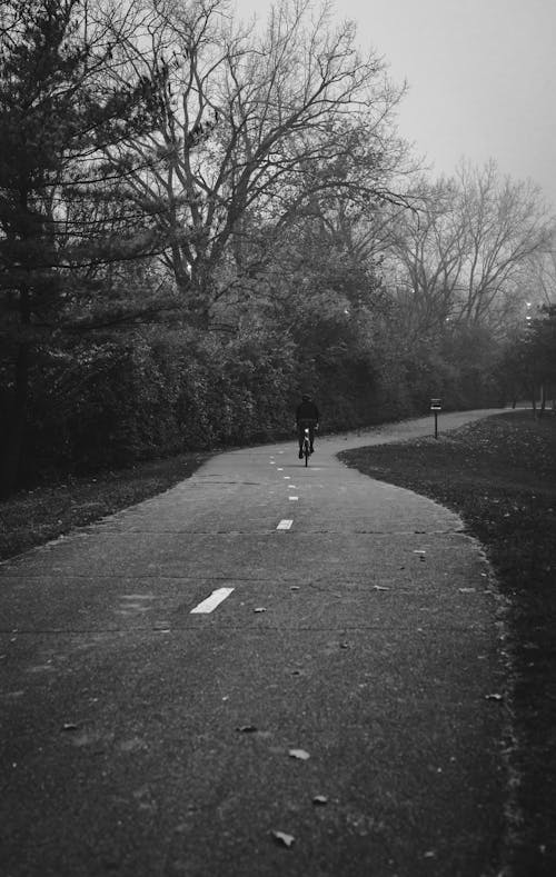 Free Black and White Photo of a Person Riding Bicycle on the Road Stock Photo