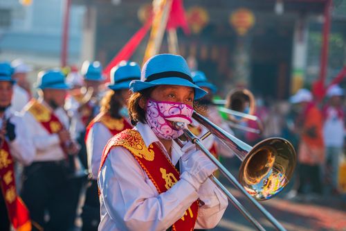 Free A colorful parade in Taiwan featuring a trombone player with festive attire and vibrant surroundings. Stock Photo