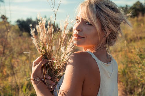 Woman in Tank Top Holding Grass